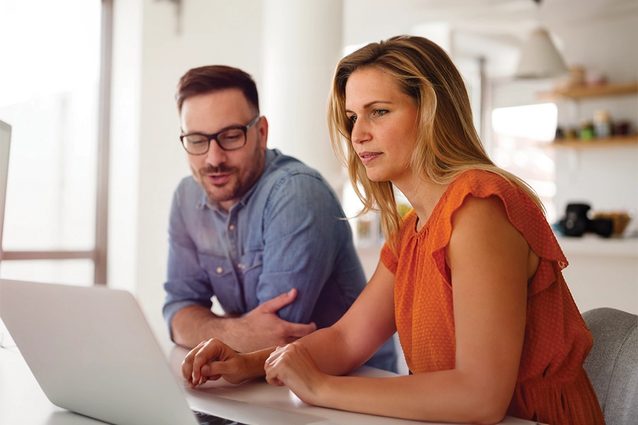 Man and woman looking at laptop at home